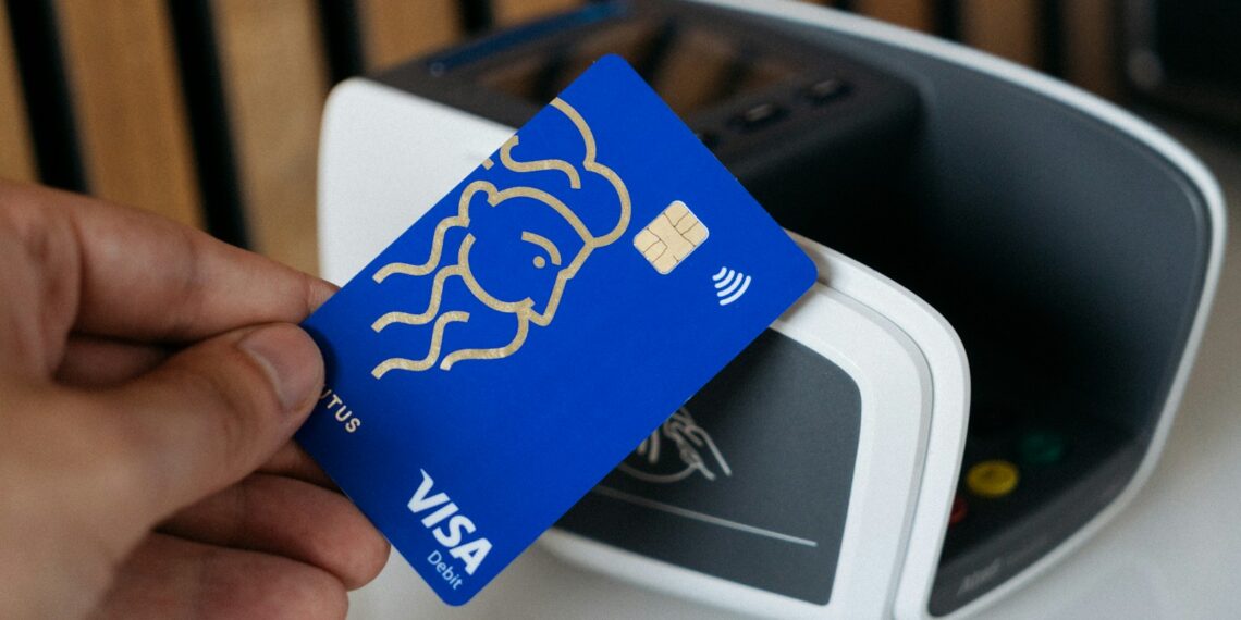 a person is holding a blue credit card