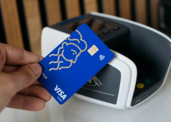 a person is holding a blue credit card