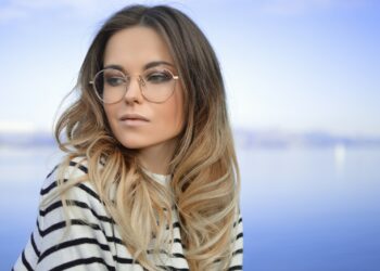 woman wearing black and white striped top and round eyeglasses