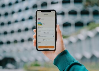 Hand holding a smartphone displaying a payment app.