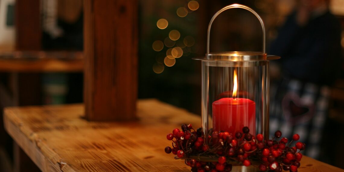 red lighted candle on brown wooden frame