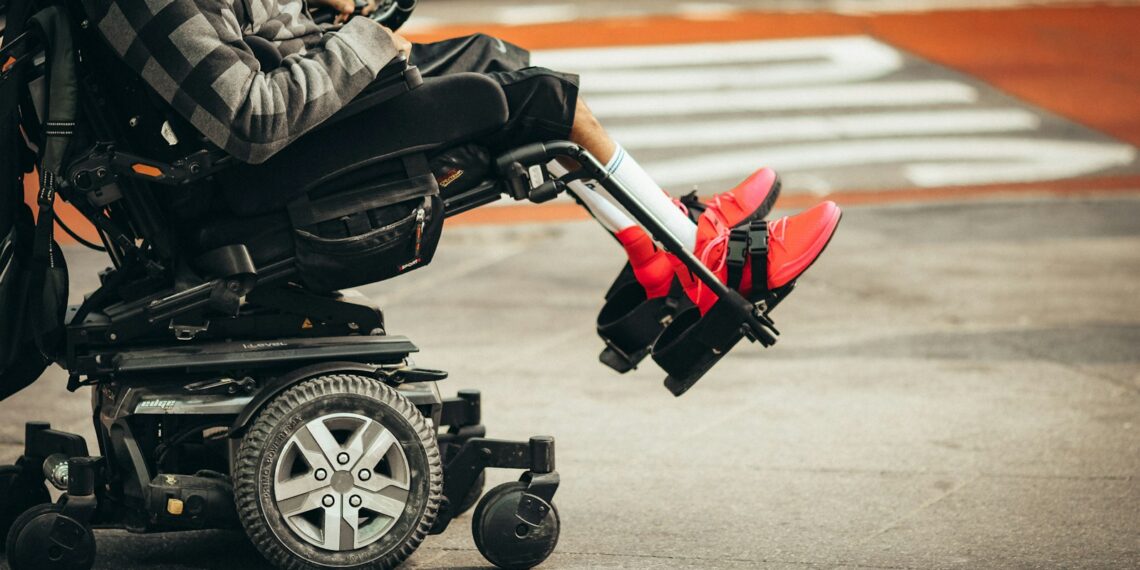 man in brown jacket and black pants riding black and red motorcycle