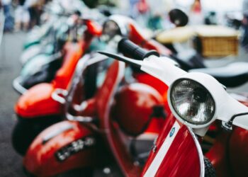 red and white motor scooter parked selective photography