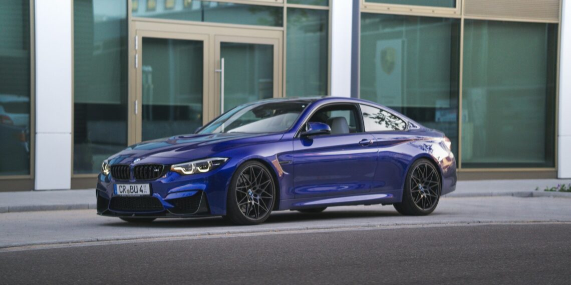 blue bmw m 3 coupe parked near white building during daytime