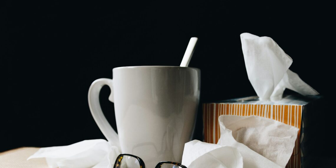 white ceramic mug on white table beside black eyeglasses