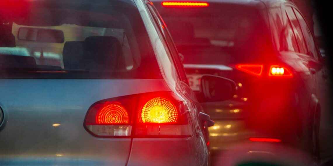 a group of cars driving down a street next to each other