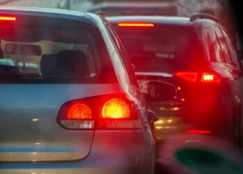 a group of cars driving down a street next to each other