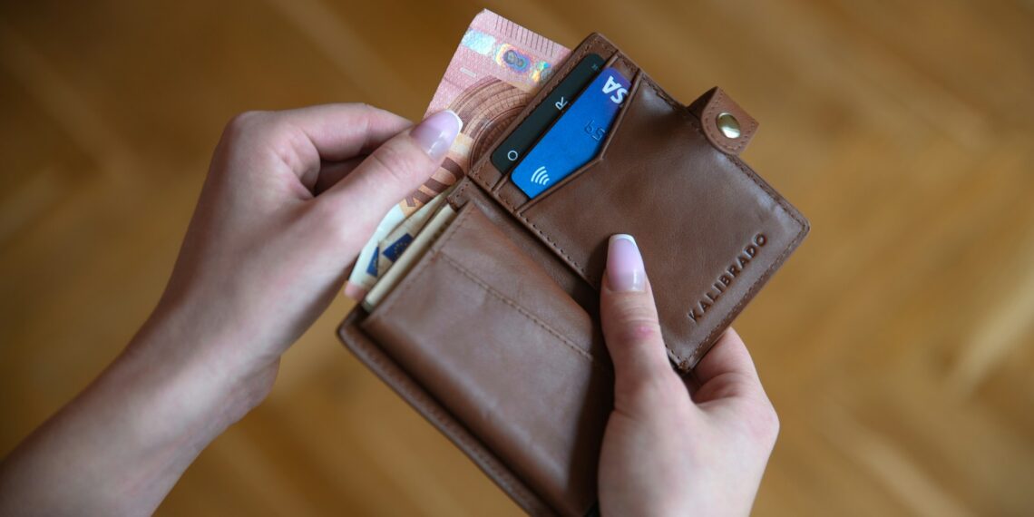 person holding brown leather card wallet