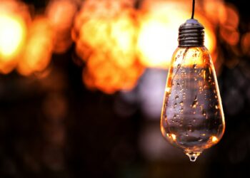 clear glass pendant lamp turned on in bokeh photography