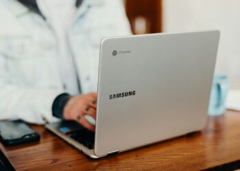 shallow focus photography of person using gray Samsung laptop