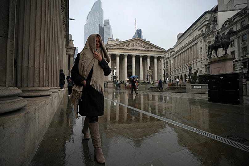 Žmonės praeina pro Anglijos banko pastatą Londono finansų rajone, 2025 m. kovo 13 d.
